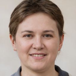 Joyful white young-adult female with short  brown hair and grey eyes