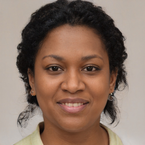 Joyful black young-adult female with medium  brown hair and brown eyes