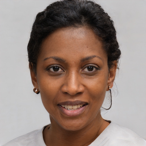 Joyful black young-adult female with short  black hair and brown eyes