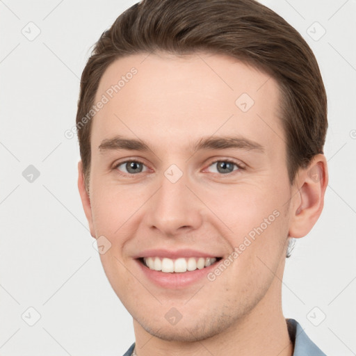 Joyful white young-adult male with short  brown hair and grey eyes