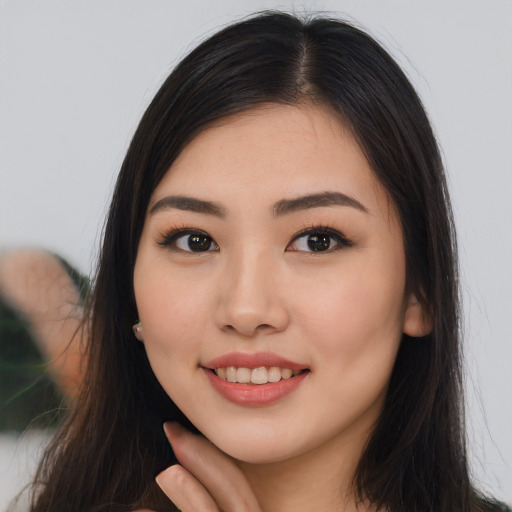 Joyful asian young-adult female with long  brown hair and brown eyes