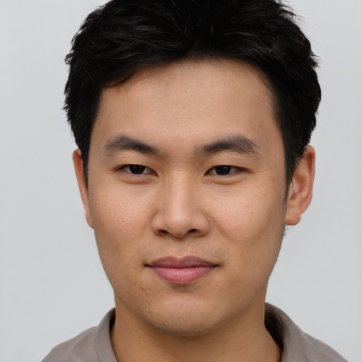 Joyful asian young-adult male with short  black hair and brown eyes