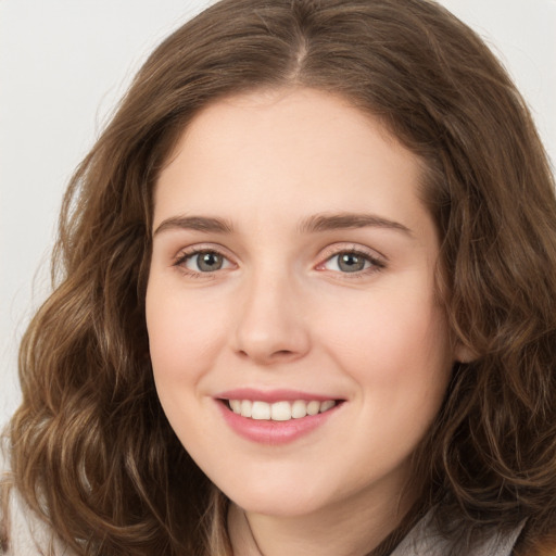 Joyful white young-adult female with long  brown hair and green eyes