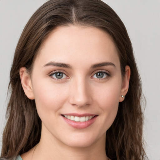 Joyful white young-adult female with long  brown hair and grey eyes