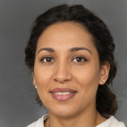 Joyful latino adult female with medium  brown hair and brown eyes