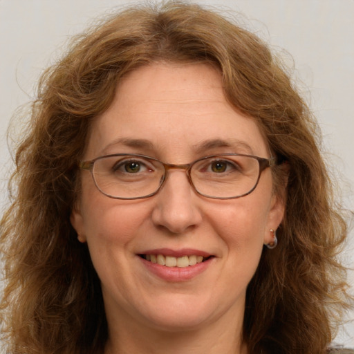 Joyful white adult female with long  brown hair and green eyes