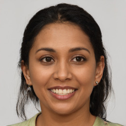 Joyful latino young-adult female with medium  brown hair and brown eyes