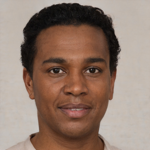 Joyful black young-adult male with short  black hair and brown eyes