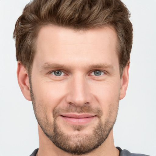 Joyful white young-adult male with short  brown hair and grey eyes