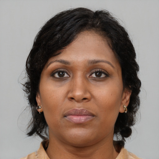 Joyful black adult female with medium  brown hair and brown eyes