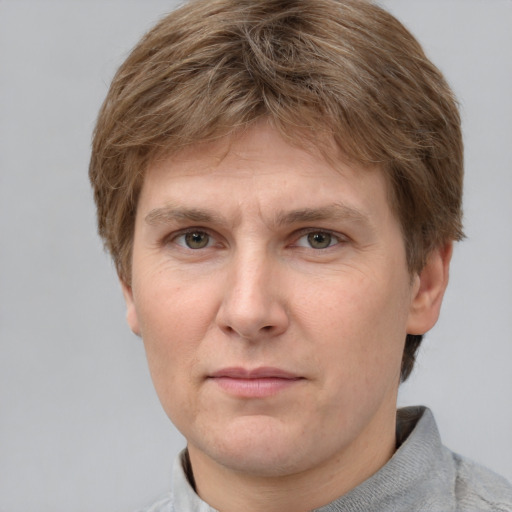 Joyful white adult male with short  brown hair and grey eyes