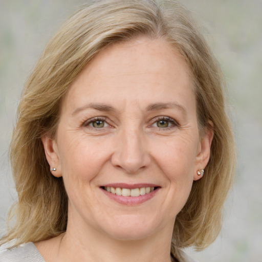 Joyful white adult female with medium  brown hair and blue eyes