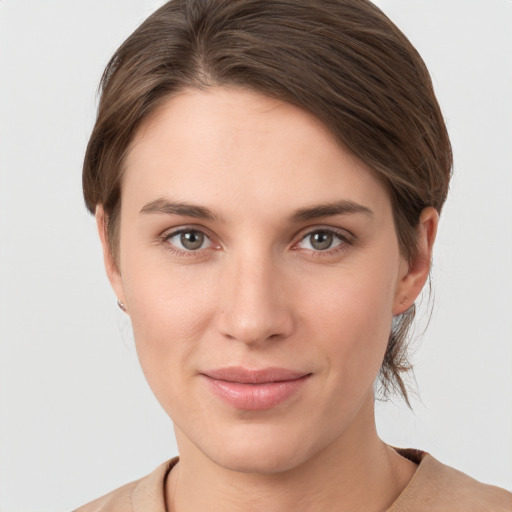 Joyful white young-adult female with medium  brown hair and grey eyes