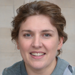 Joyful white young-adult female with medium  brown hair and blue eyes