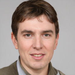 Joyful white young-adult male with short  brown hair and grey eyes