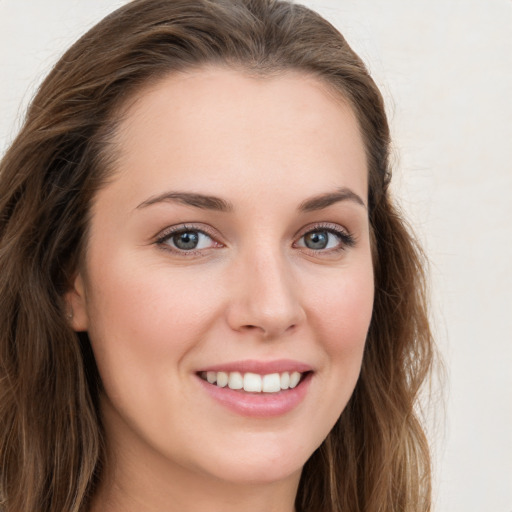 Joyful white young-adult female with long  brown hair and green eyes