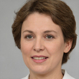 Joyful white adult female with medium  brown hair and green eyes