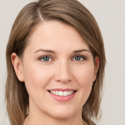 Joyful white young-adult female with medium  brown hair and grey eyes