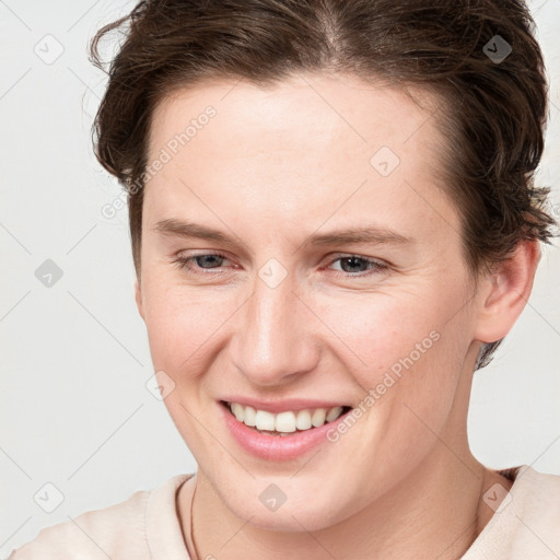 Joyful white young-adult female with short  brown hair and grey eyes