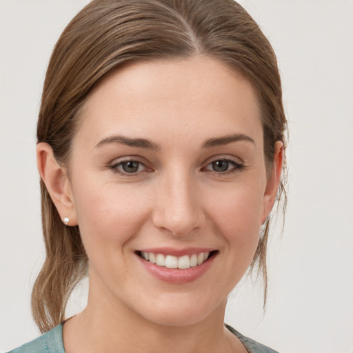 Joyful white young-adult female with medium  brown hair and grey eyes