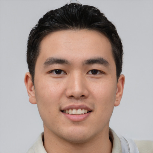 Joyful asian young-adult male with short  brown hair and brown eyes