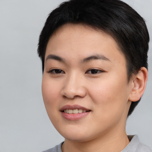 Joyful asian young-adult female with short  brown hair and brown eyes