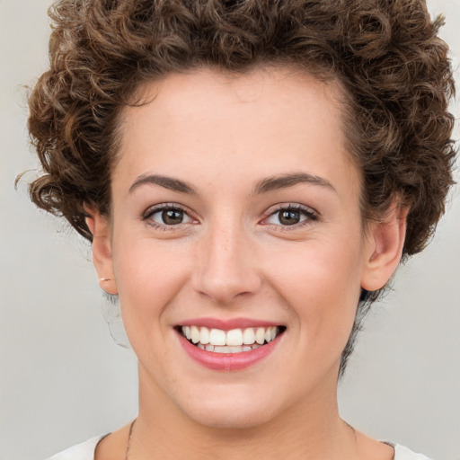 Joyful white young-adult female with short  brown hair and green eyes