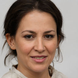 Joyful white adult female with medium  brown hair and brown eyes