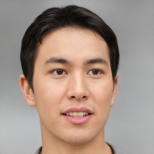 Joyful asian young-adult male with short  brown hair and brown eyes