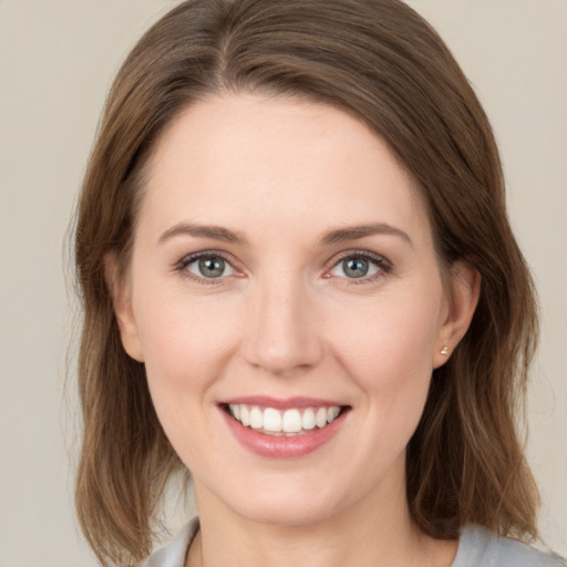 Joyful white young-adult female with medium  brown hair and green eyes