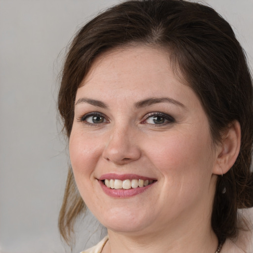 Joyful white young-adult female with medium  brown hair and grey eyes