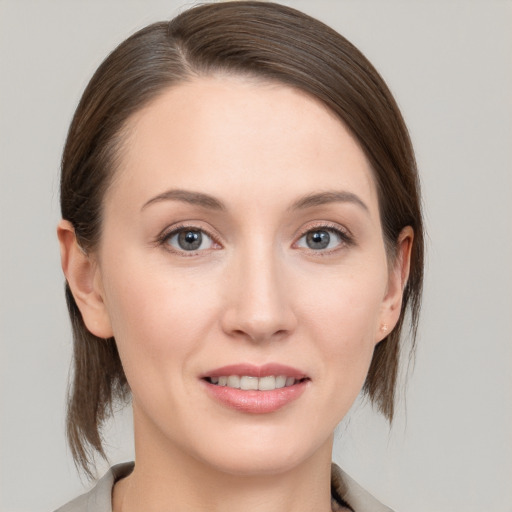 Joyful white young-adult female with medium  brown hair and grey eyes