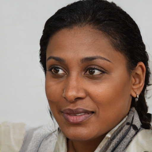 Joyful black young-adult female with long  brown hair and brown eyes