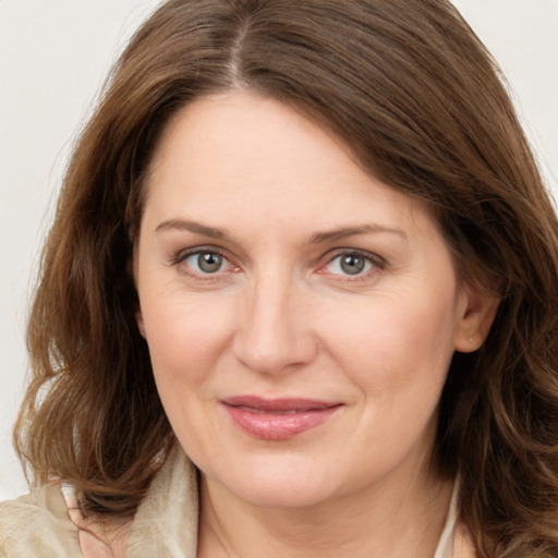 Joyful white young-adult female with long  brown hair and grey eyes