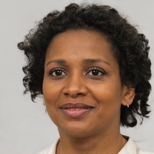 Joyful black adult female with short  brown hair and brown eyes