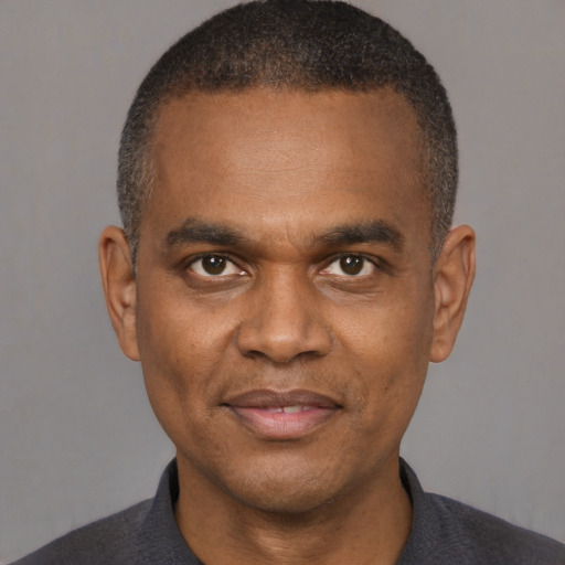 Joyful black adult male with short  black hair and brown eyes