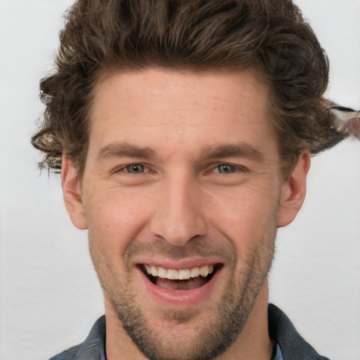 Joyful white young-adult male with short  brown hair and blue eyes