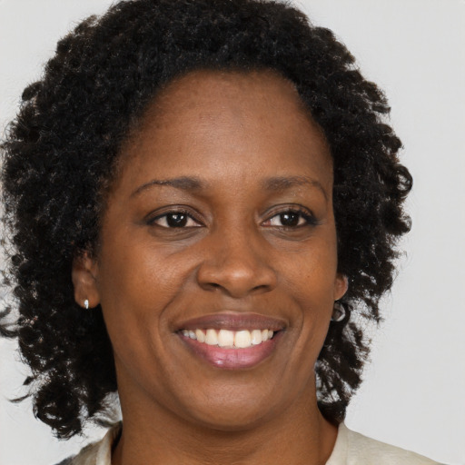 Joyful black adult female with medium  brown hair and brown eyes
