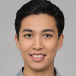 Joyful asian young-adult male with short  black hair and brown eyes