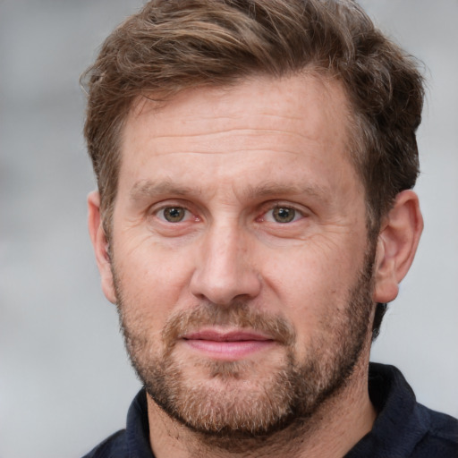 Joyful white adult male with short  brown hair and grey eyes