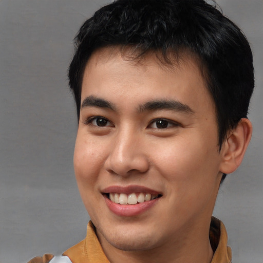 Joyful asian young-adult male with short  brown hair and brown eyes