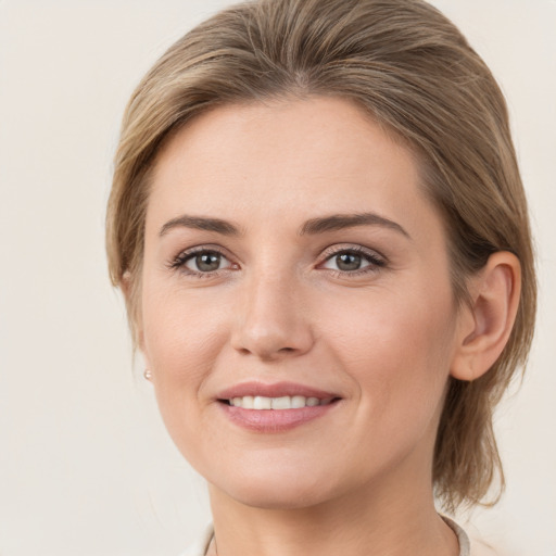 Joyful white young-adult female with medium  brown hair and grey eyes