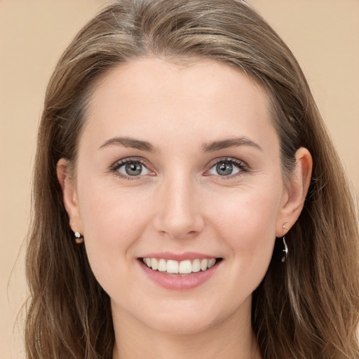 Joyful white young-adult female with long  brown hair and blue eyes