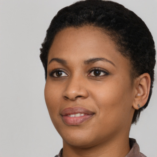 Joyful black young-adult female with short  black hair and brown eyes