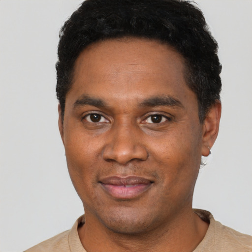 Joyful black young-adult male with short  black hair and brown eyes