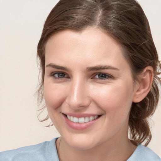 Joyful white young-adult female with medium  brown hair and blue eyes