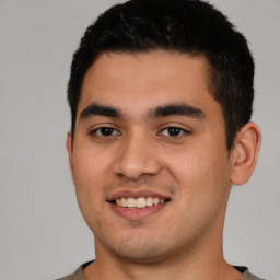 Joyful latino young-adult male with short  brown hair and brown eyes