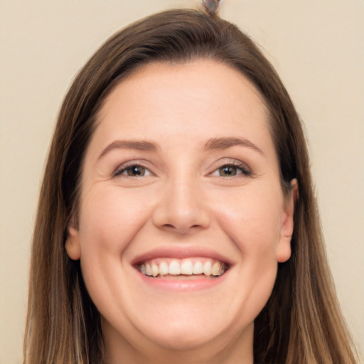 Joyful white young-adult female with long  brown hair and brown eyes