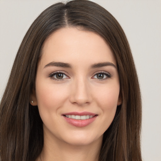 Joyful white young-adult female with long  brown hair and brown eyes