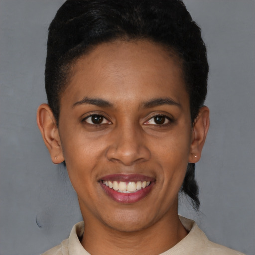 Joyful black young-adult female with short  brown hair and brown eyes
